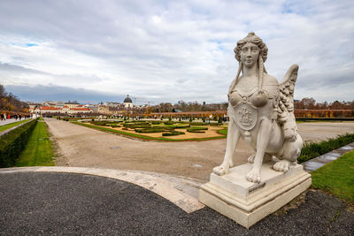 Cityscape with the garden of schloss belvedere in vienna and its statue. 