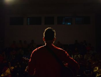 Rear view of man looking at camera