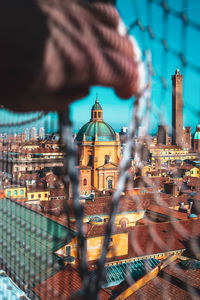 Cropped hand opening fence against townscape