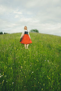 Rear view of woman standing on grassy field