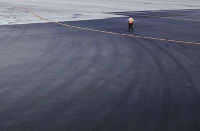 Full length of worker walking on airport runway