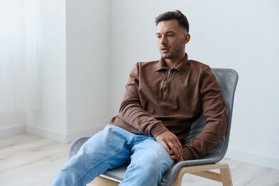 Young man sitting on sofa at home