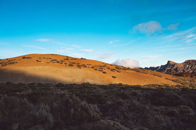 Scenic view of desert against blue sky