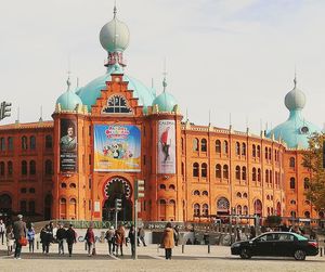 People on street against buildings in city