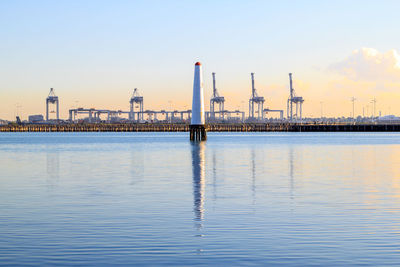 View of factory by sea against clear sky