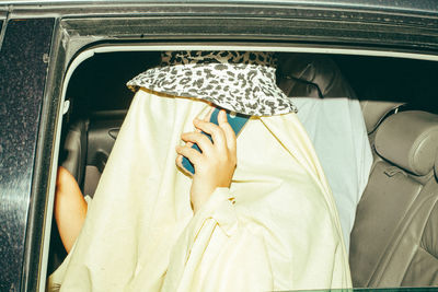 Portrait of woman holding umbrella in car