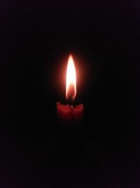 Close-up of lit candle in the dark