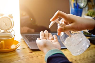 Midsection of man using laptop on table