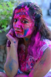 Portrait of young woman with multi colored face