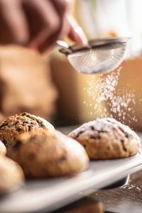 Close-up of hand holding bread in bowl