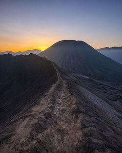 Scenic view of arid landscape against sky during sunset