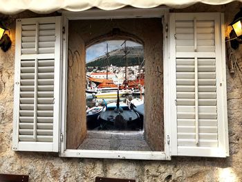 Buildings seen through open window of building