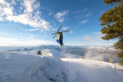 Man skiing on snowcapped mountain against sky