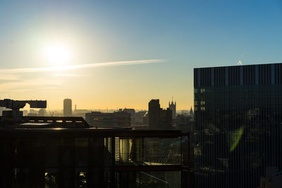 Buildings in city against sky during sunset