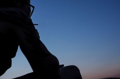 Close-up of silhouette hand against clear sky