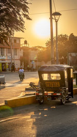 Cars on street in city at sunset