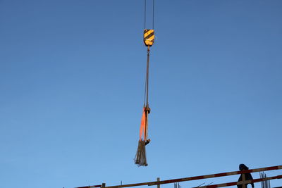 Low angle view of crane against clear sky