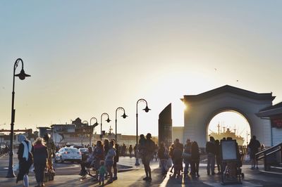 People walking on road against clear sky