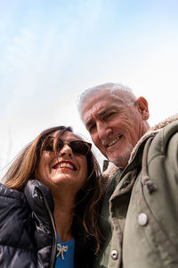 Happy middle aged couple taking a selfie in front a dinosaur in a public park