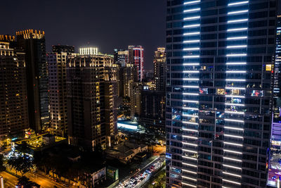 Illuminated buildings in city against sky at night