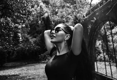 Young woman tying hair while standing outdoors