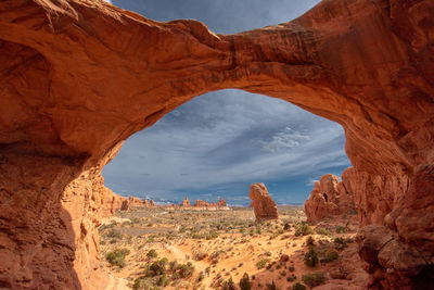 Low angle view of rock formations against cloudy sky