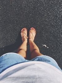 Low section of woman standing on road