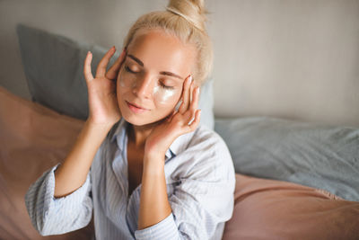 Young woman sitting on sofa at home