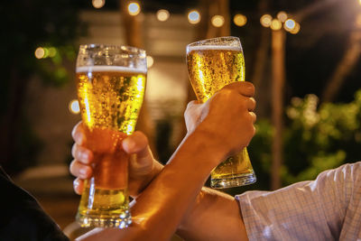 Midsection of man holding beer glass