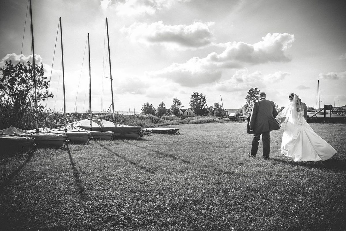 sky, leisure activity, tree, lifestyles, full length, rear view, cloud - sky, men, transportation, person, casual clothing, mode of transport, childhood, nautical vessel, cloud, swing, water