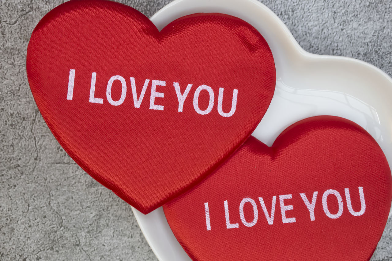 CLOSE-UP OF TEXT ON RED HEART SHAPE ON TABLE