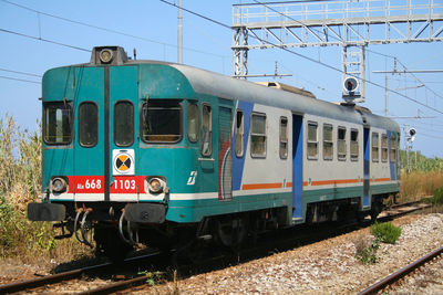 Train at railroad tracks against clear sky