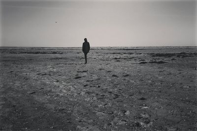 Silhouette of woman in sea against clear sky