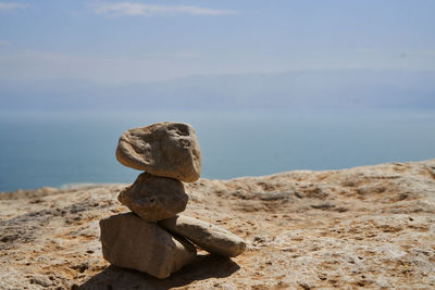 Stack of stones on beach against sky