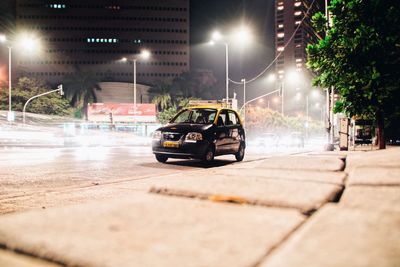 Car on illuminated street in city at night