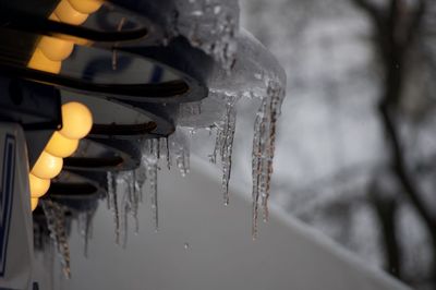 Close-up of icicles hanging from metal canopy of a cafe in montmartre, paris 