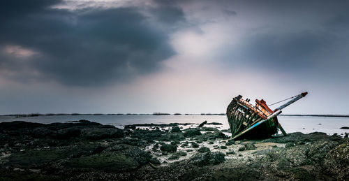 Traditional windmill on beach against sky