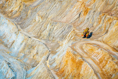 High angle view of mining vehicle on rock in quarry