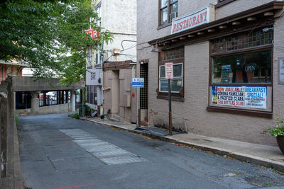 Empty road amidst buildings in city