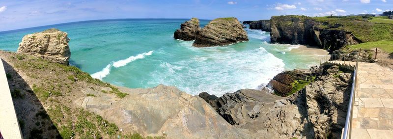 Panoramic view of rocks on beach against sky