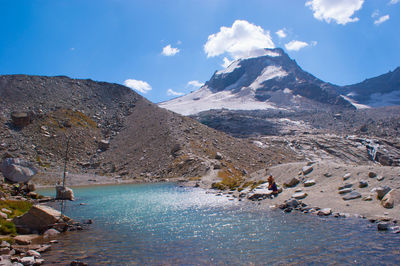 Scenic view of lake by mountains against sky