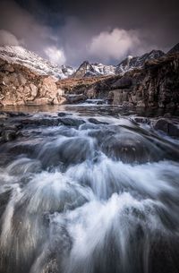 Scenic view of frozen lake against mountain during sunset