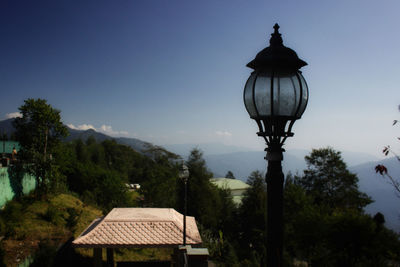 Street light by building against sky