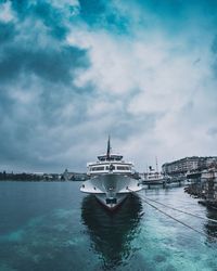 Ship moored at harbor against sky