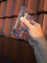 Close-up of hand holding glass of water