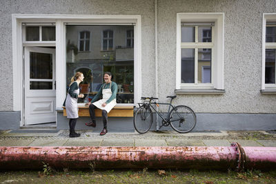 Happy male and female colleagues outside art studio