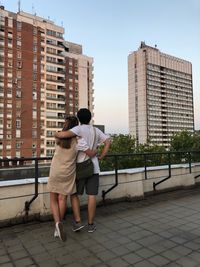 Rear view of friends walking on street in city