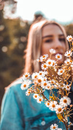 Portrait of teenage girl standing by flowers