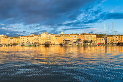 Scenic view of saint-tropez in a golden warm sunset light against dramatic blue sky with clouds