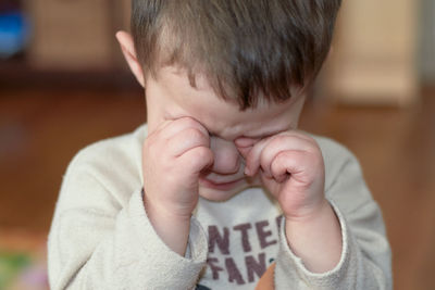 Little boy crying and rubbing his eyes